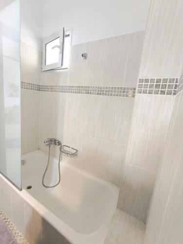 a bathroom with a bath tub with a shower at Tranquil central apartment in Ampavris