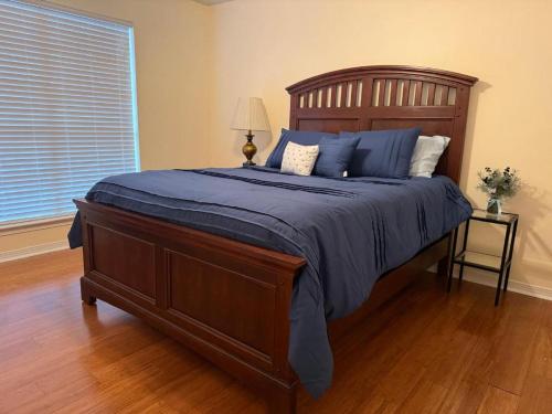a bedroom with a bed with blue sheets and a window at WildFlower Inn in Satsuma
