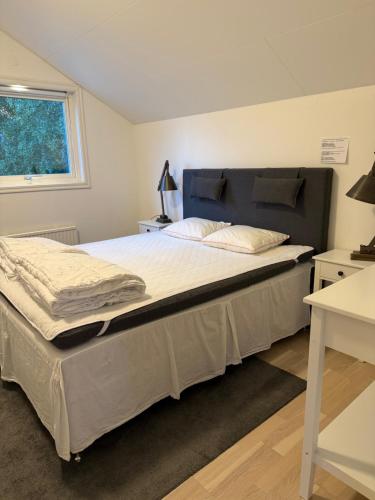 a large bed in a bedroom with a window at Lägenhet ovanför stall in Färjestaden