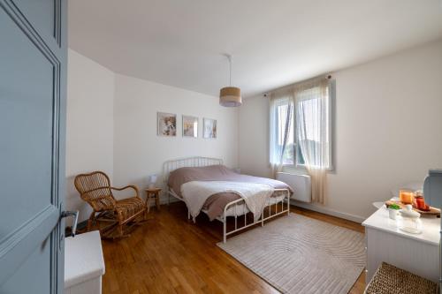 a bedroom with a bed and a table and a window at La lande appart in Tranzault