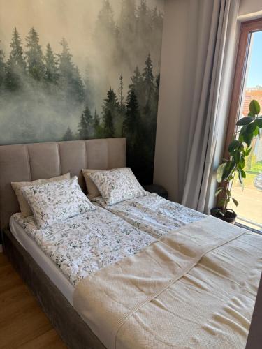 a bed in a bedroom with a painting on the wall at Piska Przystań in Pisz
