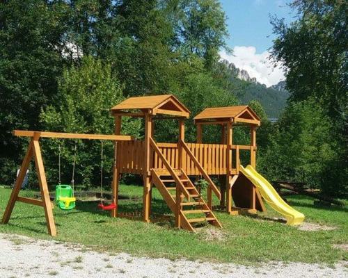 a wooden playground with a slide and a gazebo at Penzión Štefánik in Súľov