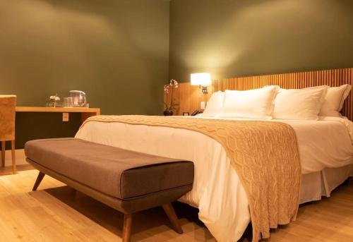 a bedroom with a large white bed with a ottoman at Spa Tour Life in Montenegro
