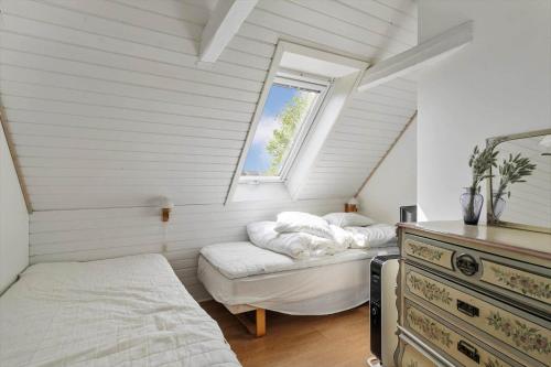 a attic bedroom with two beds and a window at 20623-Samso-Besser-Hovedgade-9 in Besser