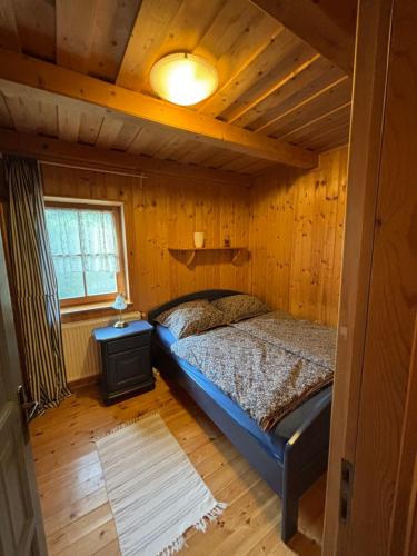 a bedroom with a bed in a wooden house at Kinga House in Keszthely