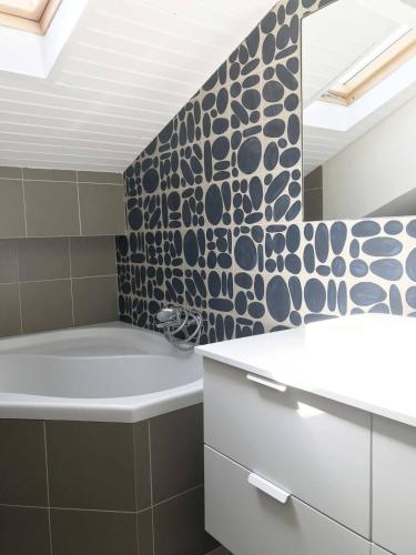 a bathroom with a bath tub and a mirror at La Mansarde du Port FAMILLY HOME in Nice