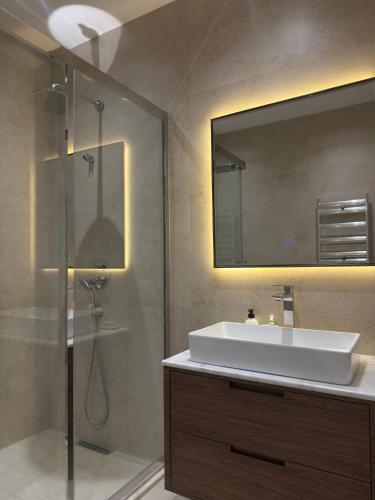 a bathroom with a sink and a shower with a mirror at escape gabala in Vǝndam