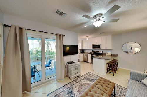 a living room with a couch and a kitchen with a balcony at Beachside Villas #413 in Seagrove Beach