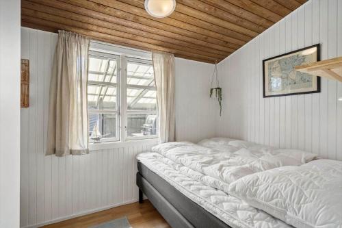 a bed in a room with a window at 2236-Ringkobing-Fladsbjergvej-220 in Klegod