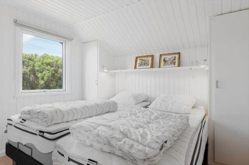 two beds in a room with a window at OH592-Hadsund-Haslevgaarde-Bakker-12 in Øster Hurup