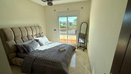 a bedroom with a large bed and a window at Appartement cosy in Agadir