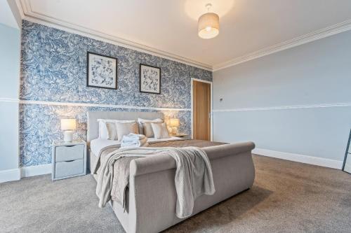 a bedroom with a bed and a blue wall at Bay Apartment 2 in Morecambe