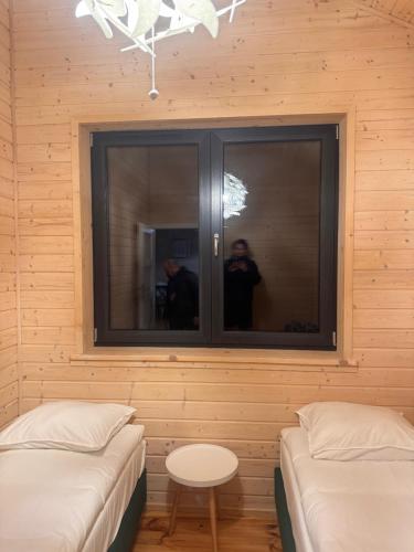 a man taking a picture in a room with two beds at Gubławki Resort in Gubławki