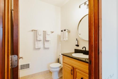 a bathroom with a toilet and a sink and a mirror at Mt Merritt Suite Boutique Hotel Experience in Kalispell