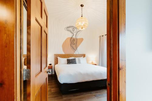 a bedroom with a bed and a chandelier at Mt Merritt Suite Boutique Hotel Experience in Kalispell
