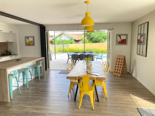 a kitchen and dining room with a table and chairs at Chai Nous - votre villa au cœur des Landes - classée 4 étoiles in Rion-des-Landes