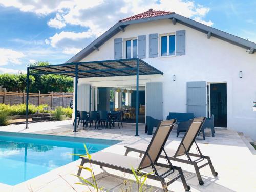 a villa with a swimming pool and a house at Chai Nous - votre villa au cœur des Landes - classée 4 étoiles in Rion-des-Landes