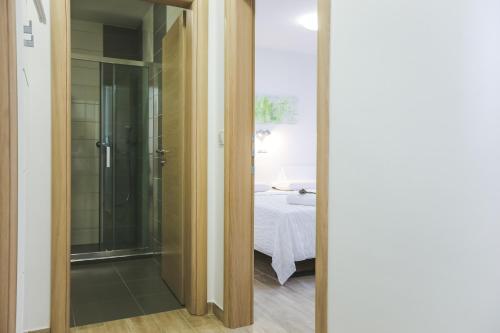 a bathroom with a glass door leading to a bedroom at Apartments Sesar in Rab