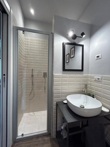 a bathroom with a white sink and a shower at Casa di Piera in Poggibonsi