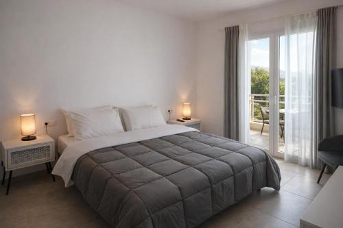 a bedroom with a large bed and a balcony at Aroniadika rooms in Kythira
