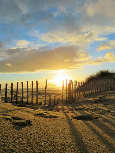 a fence on the beach at sunset at Leamington House in Barmouth