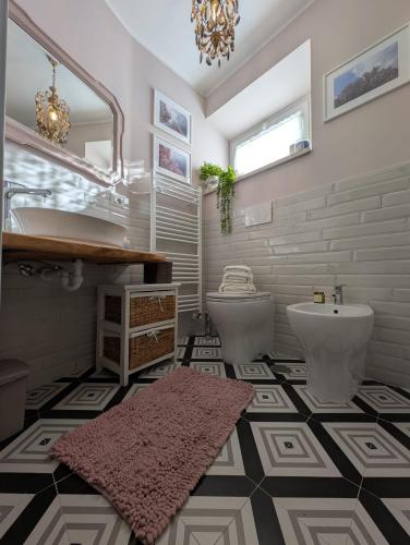 a bathroom with two toilets and a sink at Casa Mita - accogliente monolocale nel cuore del paese in Marta