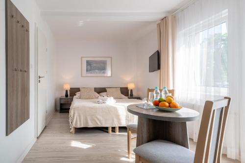 a bedroom with a bed and a table with a bowl of fruit at DOM GOŚCINNY ROMA in Rewal