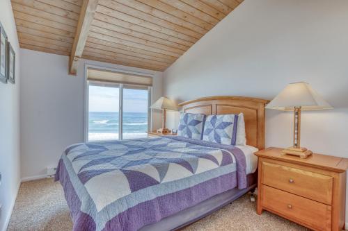 a bedroom with a bed and a window with the ocean at Breakers Beach House 7 in Neskowin