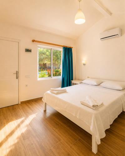 a bedroom with a large bed and a window at Doğa Pansiyon in Marmaris