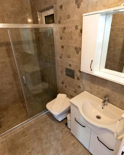 a bathroom with a shower and a toilet and a sink at Doğa Pansiyon in Marmaris