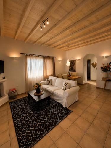 a living room with a white couch and a table at Infinity View Villas Mykonos in Kalo Livadi