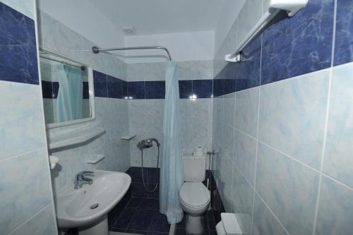 a bathroom with a white toilet and a sink at Babis Hotel in Karterados
