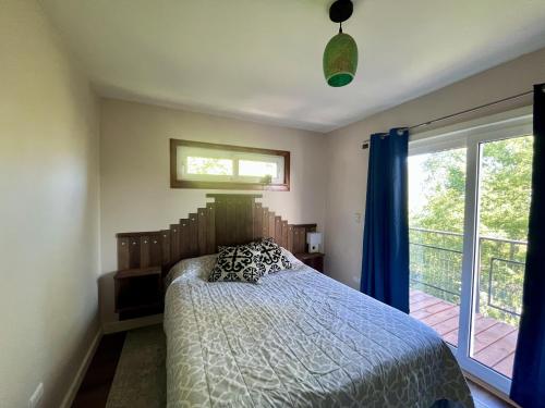 a bedroom with a bed and a large window at Oceana Suites Panguipulli in Panguipulli