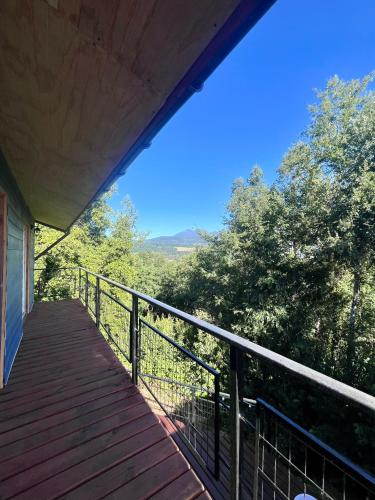 a balcony of a house with a view of trees at Oceana Suites Panguipulli in Panguipulli