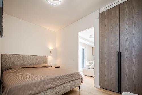a bedroom with a bed and a wooden cabinet at Nida Breeze Apartments in Neringa