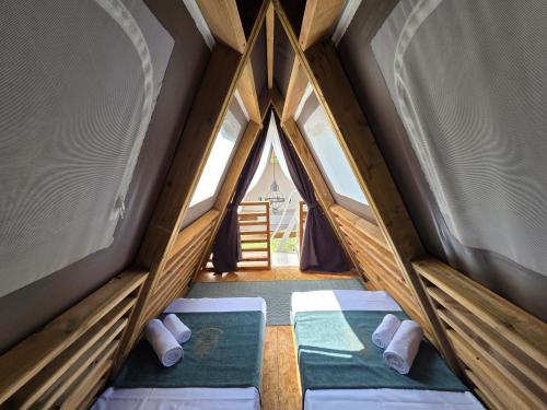 two beds in a room with two windows at Green Glamping Paravia in Krasica