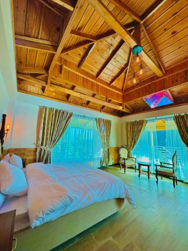 a bedroom with a large bed in a room with wooden ceilings at Pine Peaks Heaven in Nathia Gali