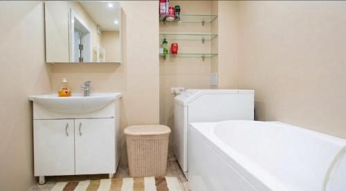 a bathroom with a sink and a tub and a toilet at Central cozy apartments- one and two bedrooms option in Chişinău