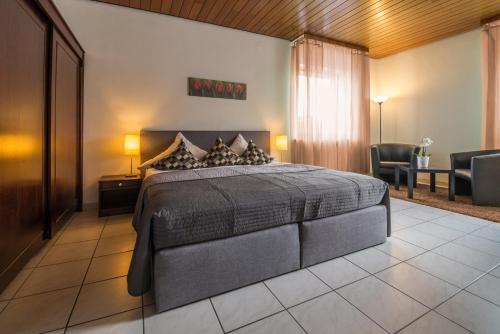 a bedroom with a bed and a table and chairs at Hotel Landgasthaus Sockenbacher Hof in Strümpfelbrunn
