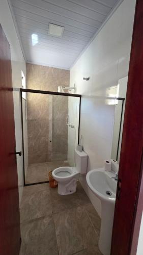 a bathroom with a toilet and a sink at Pousada Serra do Sol in Mariana