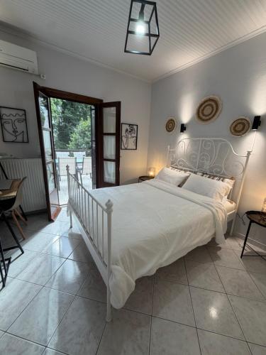 a bedroom with a large white bed and a balcony at The Big apartment Papa Nero Pelion in Agios Ioannis Pelio