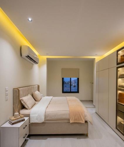 a bedroom with a large bed and a tv at Luna Villa in Al Khobar
