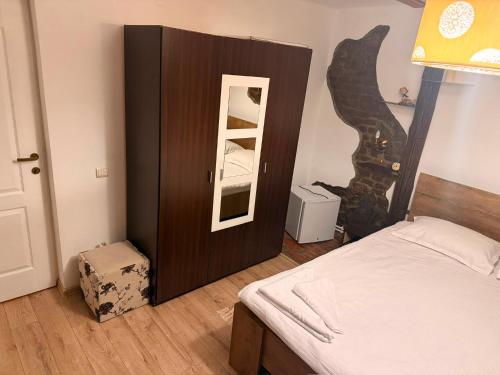 a bedroom with a wooden cabinet with a mirror at Casa Cosmin in Dobra
