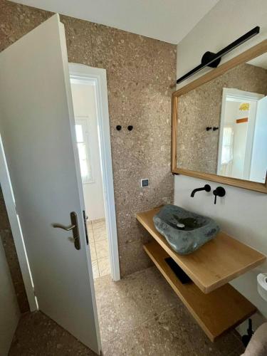 a bathroom with a sink and a mirror at Rocky Beach House in Kythira