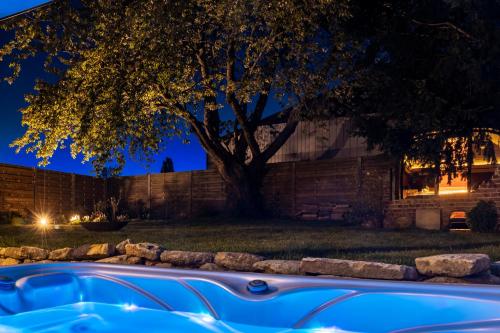 a tree and a hot tub in a yard at night at Wellnesshoeve in Boutersem