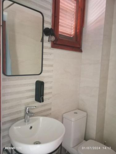 a bathroom with a sink and a mirror and a toilet at Grandpa BILL's house 6 in Pyrgadikia