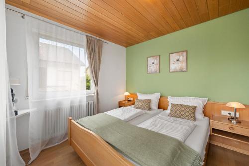 a bedroom with a bed and a large window at Ferienhaus Seehang in Meersburg