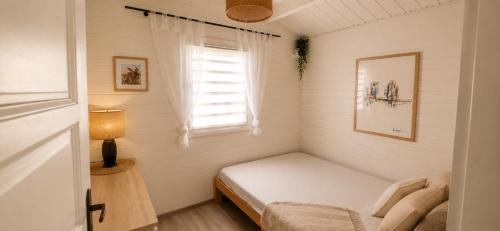 a small bedroom with a bed and a window at Domek ASIA in Wronka