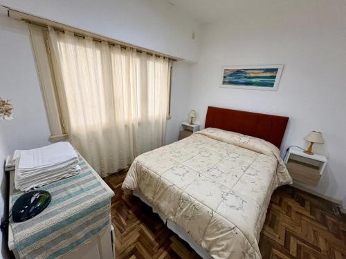 a small bedroom with a bed and a window at Alsina Mdq in Mar del Plata