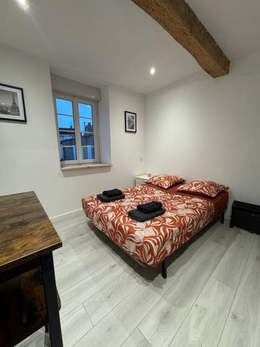 a bedroom with a bed and a wooden floor at Les Perles de Limoux -Studio Centre Climatiseur Wifi Parking Gratuit in Limoux